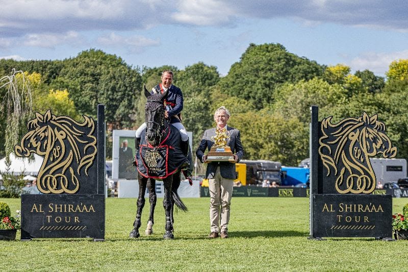 Robert Whitaker is presented with the Al Shira'aa King George V Gold Cup by BHS President Martin Clunes